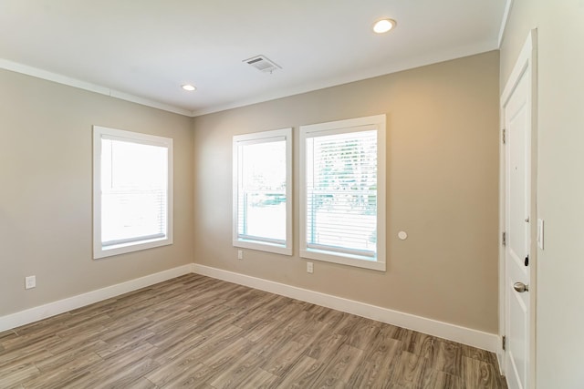 6605 Greenhurst St, Houston, TX 77091 - empty room featuring plenty of natural light, light wood-style floors, baseboards, recessed lighting, and ornamental molding