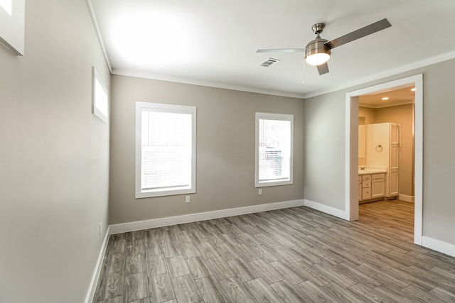 unfurnished bedroom with ensuite bathroom, ornamental molding, light wood-type flooring, and ceiling fan