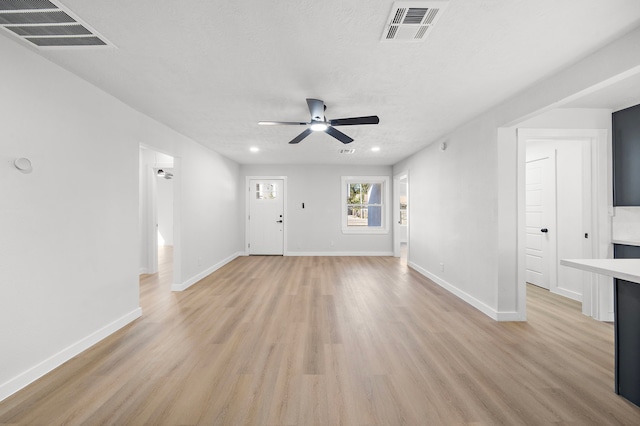 unfurnished room featuring ceiling fan, a textured ceiling, and light wood-type flooring