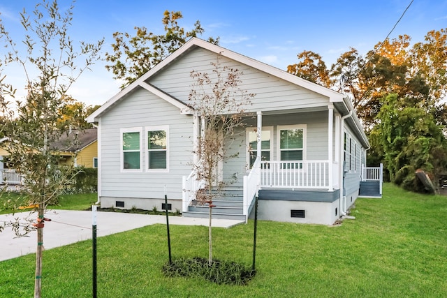 bungalow with a porch and a front lawn