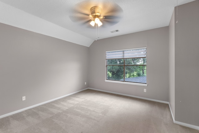 unfurnished room featuring a textured ceiling, ceiling fan, light colored carpet, and lofted ceiling