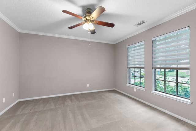 unfurnished room with a textured ceiling, ceiling fan, crown molding, and light carpet