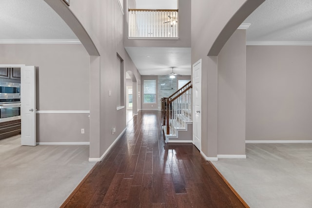 foyer entrance with carpet flooring, a textured ceiling, and ceiling fan with notable chandelier