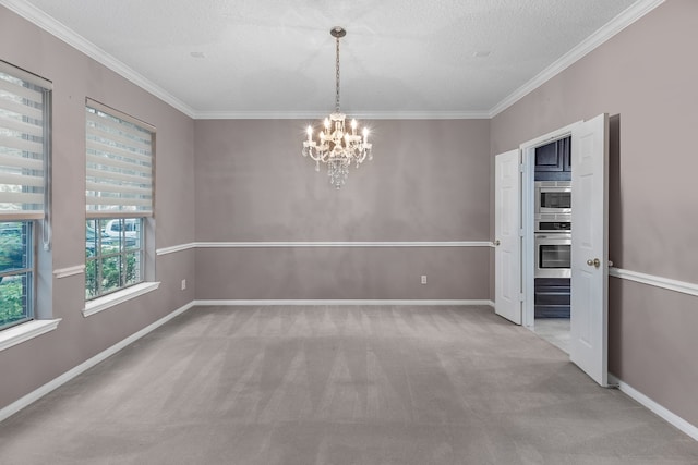 carpeted empty room featuring ornamental molding, a textured ceiling, and a notable chandelier