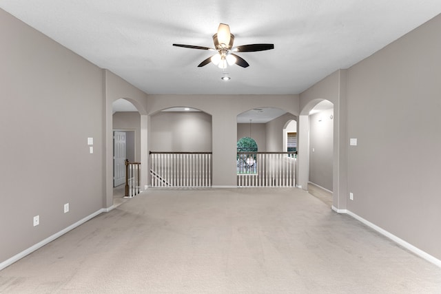 spare room with a textured ceiling, carpet floors, and ceiling fan