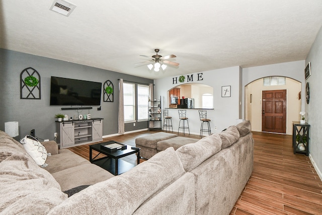 living room with wood-type flooring and ceiling fan