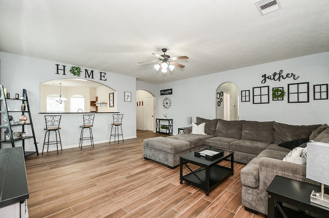 living room with hardwood / wood-style floors and ceiling fan with notable chandelier