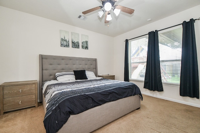 bedroom with light carpet, multiple windows, and ceiling fan