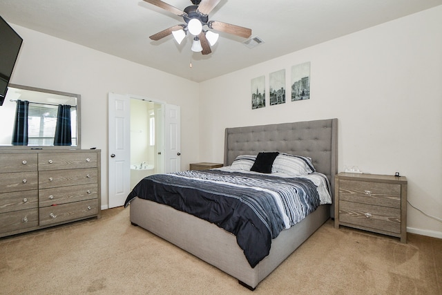 carpeted bedroom with ensuite bath and ceiling fan