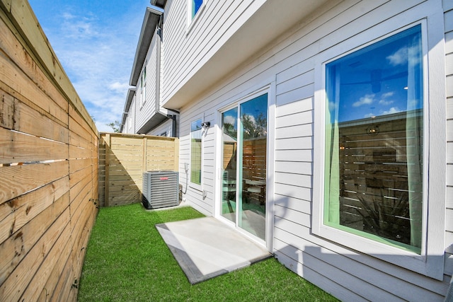 exterior space with central air condition unit and a yard