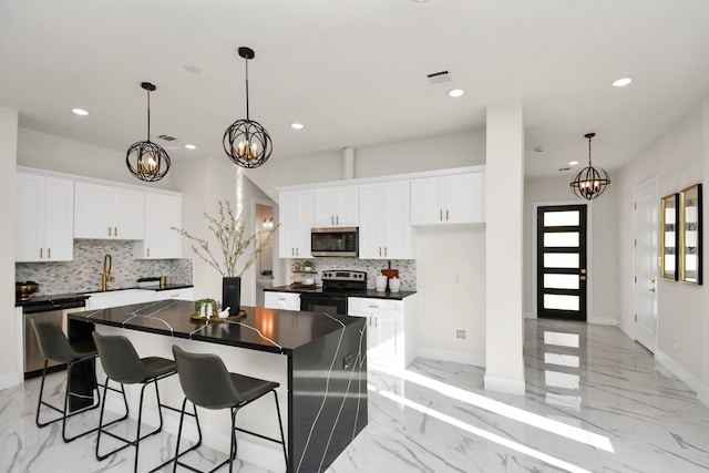 kitchen featuring a center island, decorative backsplash, white cabinets, and stainless steel appliances