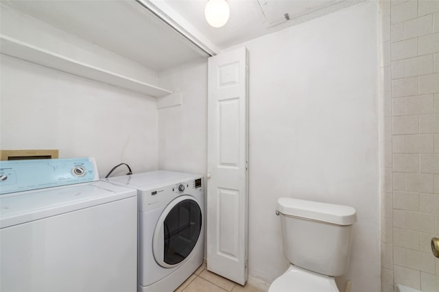 clothes washing area featuring light tile patterned flooring and independent washer and dryer