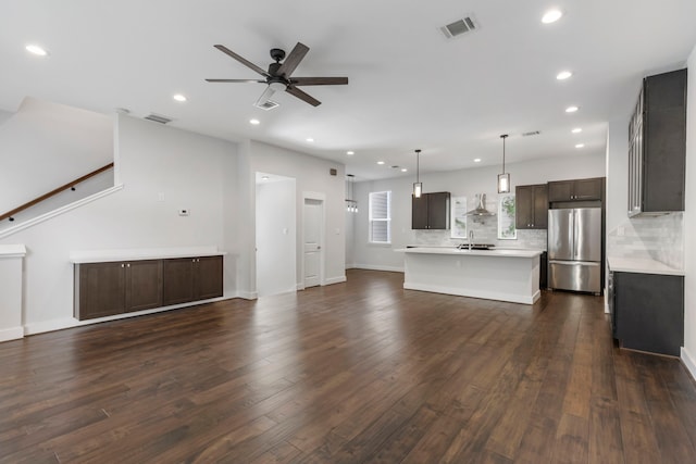 unfurnished living room featuring sink, dark wood-type flooring, and ceiling fan