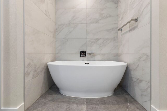 bathroom with a bathing tub and tile walls