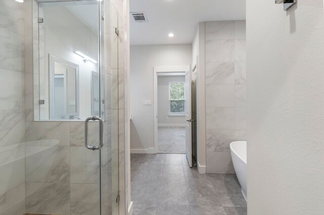 bathroom featuring shower with separate bathtub and tile patterned floors