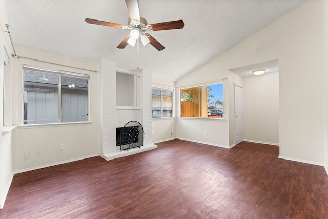 unfurnished living room featuring lofted ceiling, dark wood-type flooring, a textured ceiling, and ceiling fan