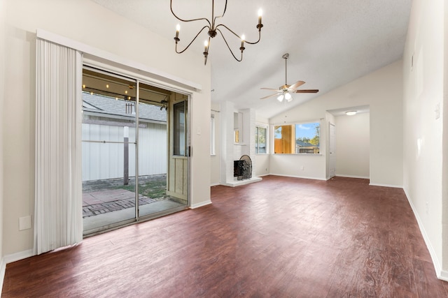 unfurnished living room featuring lofted ceiling, a brick fireplace, hardwood / wood-style flooring, and ceiling fan with notable chandelier