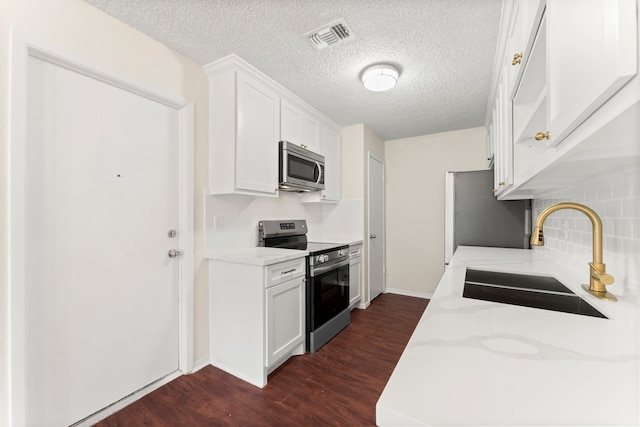 kitchen with white cabinetry, stainless steel appliances, dark wood-type flooring, and sink