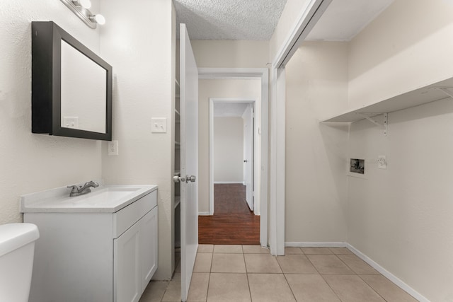 bathroom featuring vanity, a textured ceiling, toilet, and tile patterned flooring