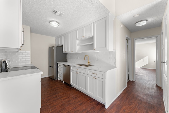 kitchen with backsplash, appliances with stainless steel finishes, dark hardwood / wood-style flooring, white cabinetry, and sink