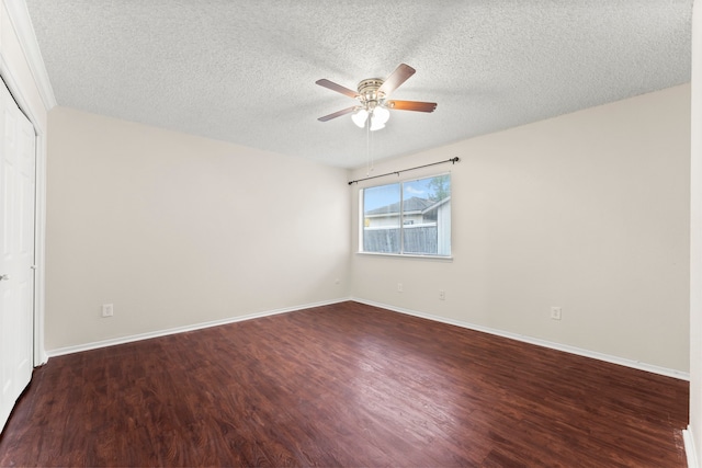 spare room with a textured ceiling, ceiling fan, and dark hardwood / wood-style flooring