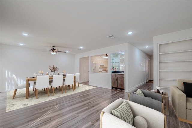 interior space with ceiling fan, hardwood / wood-style flooring, and built in features