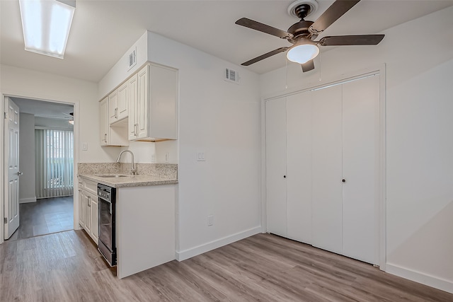 kitchen featuring light hardwood / wood-style floors, white cabinetry, sink, and ceiling fan