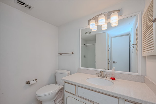 bathroom with vanity, toilet, and a shower with door