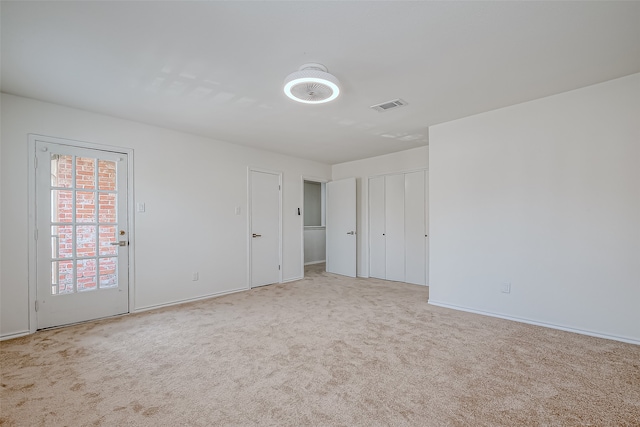 unfurnished room featuring light colored carpet