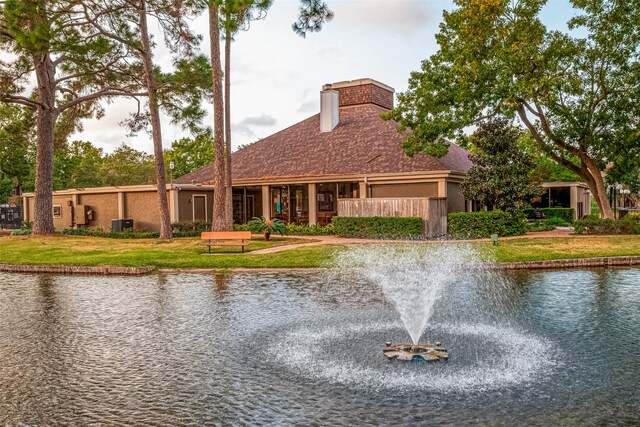 view of front facade with a water view and a front lawn