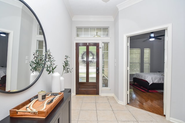 tiled entryway featuring ceiling fan and crown molding