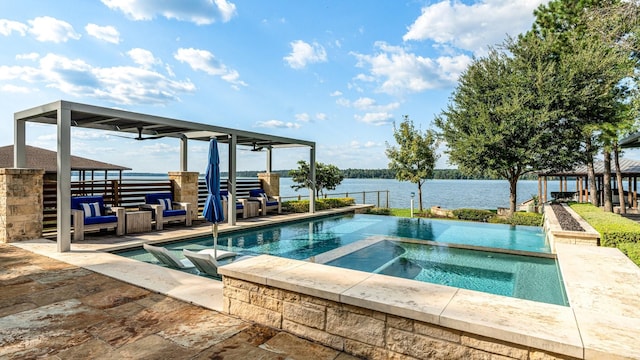 view of swimming pool with an in ground hot tub and a water view