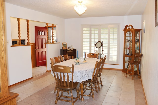 dining room with a textured ceiling and light tile patterned floors