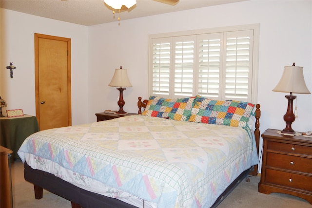 bedroom with carpet, a textured ceiling, and ceiling fan