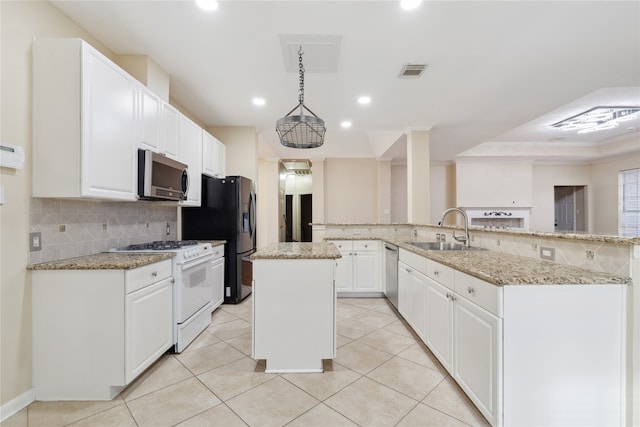 kitchen with a kitchen island, kitchen peninsula, stainless steel appliances, sink, and decorative light fixtures