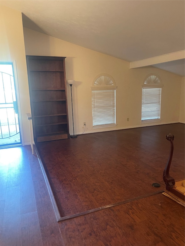 unfurnished living room with vaulted ceiling and dark hardwood / wood-style flooring