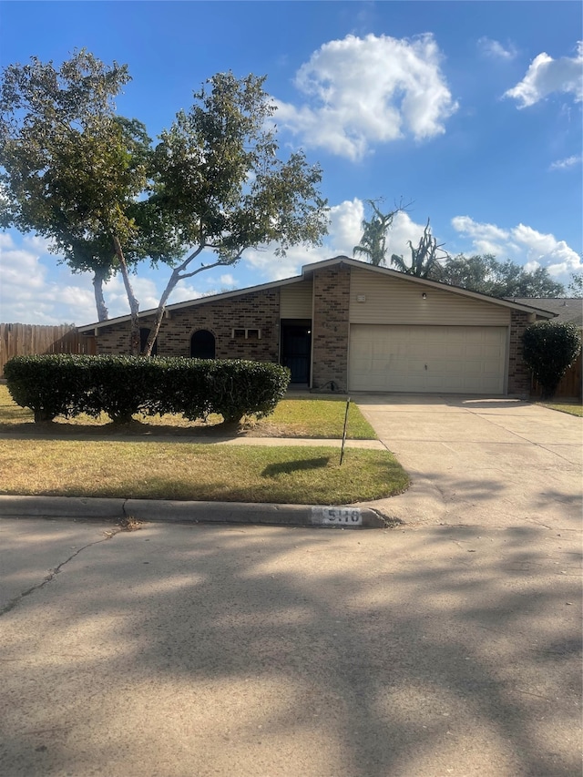 ranch-style home with a front lawn and a garage