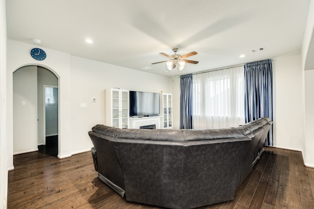 living room featuring dark wood-type flooring and ceiling fan