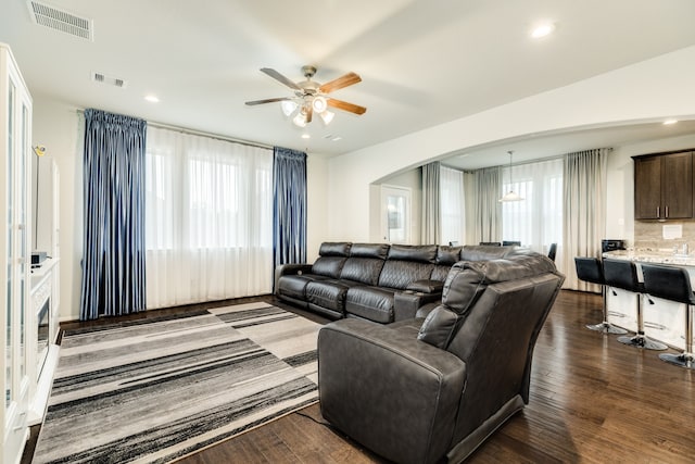 living room featuring ceiling fan, plenty of natural light, and dark hardwood / wood-style floors