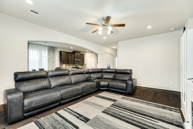 living room with dark wood-type flooring and ceiling fan