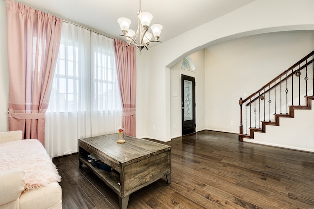 living room with a notable chandelier and dark hardwood / wood-style flooring