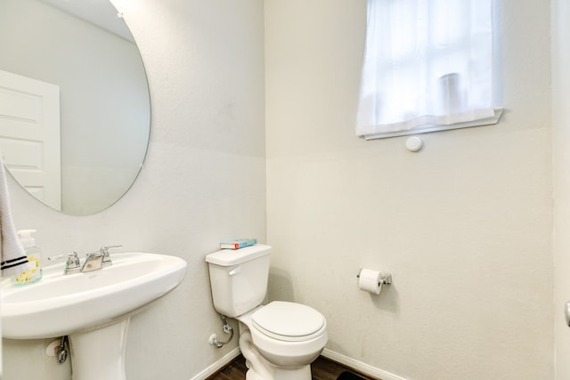 bathroom featuring toilet, hardwood / wood-style floors, and sink