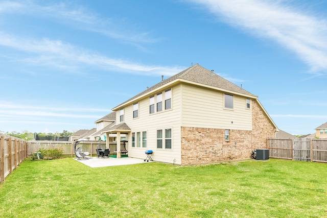 rear view of house with a yard, a patio area, and central AC unit