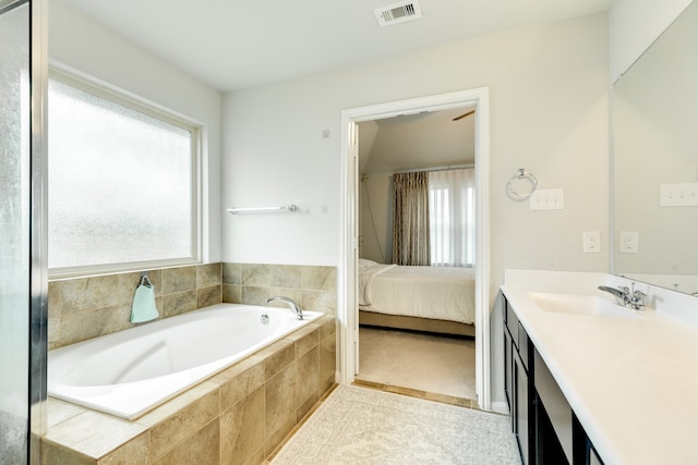 bathroom featuring vanity and tiled bath