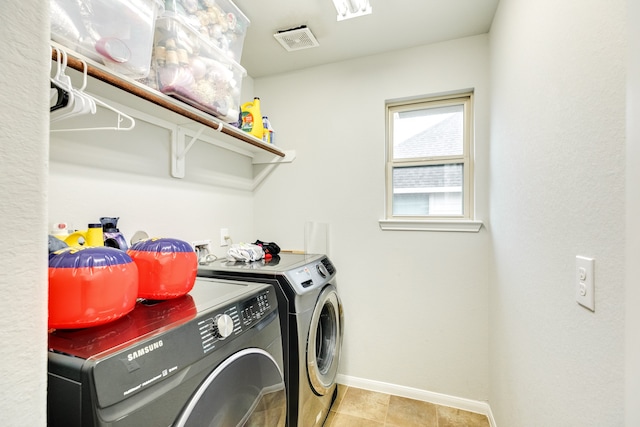 laundry room with light tile patterned flooring and washer and clothes dryer