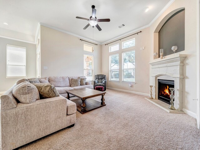 carpeted living room with ceiling fan and crown molding