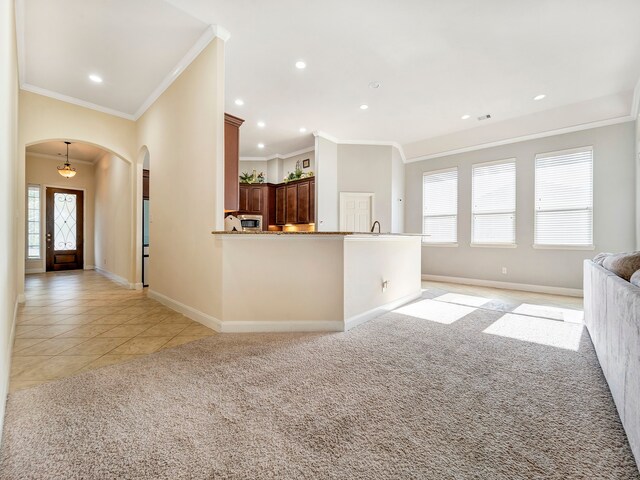 unfurnished living room with light colored carpet and crown molding