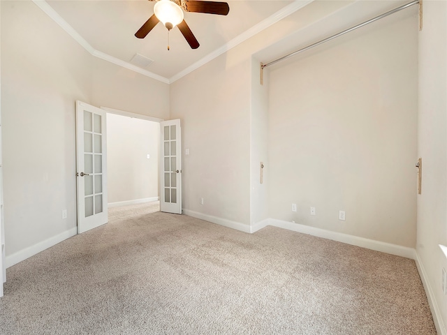 carpeted empty room with french doors, ceiling fan, and crown molding