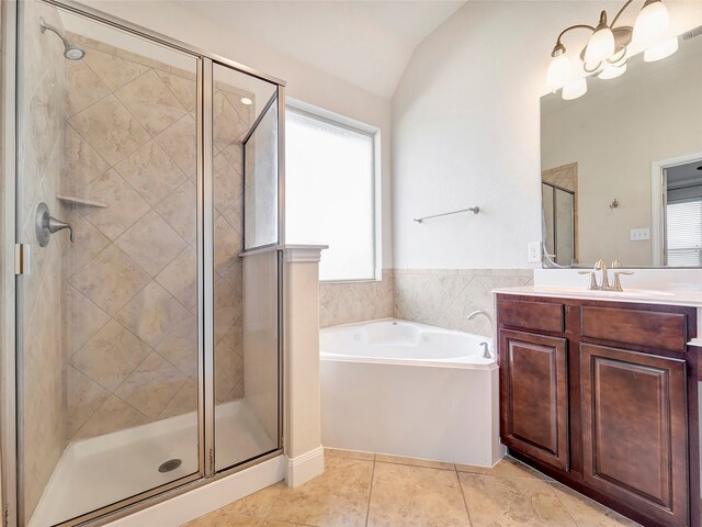 bathroom with plenty of natural light, shower with separate bathtub, vanity, and vaulted ceiling