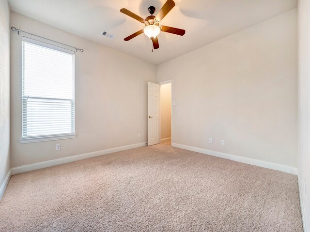 carpeted spare room with ceiling fan